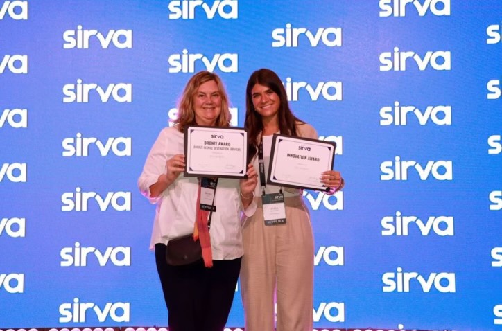 Two women holding certificates in front of a blue background.